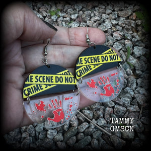 These awesome crime scene inspired earrings feature a bloodied hand print hanging beneath a cautionary crime scene sign, measuring approx 6.5cms from tip to tip and weighing only a few grams each.

This pair has been made with stainless steel french hooks, suitable for pierced ears.