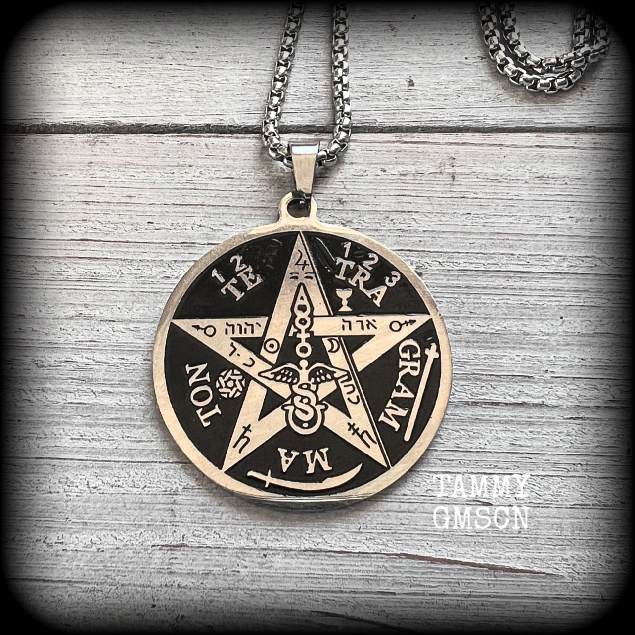 Measuring 16" when laying flat and fastening with an antique silver lobster clasp, this necklace features a stainless steel silver and black Tetragrammaton pendant.

The pendant on this necklace measures approx 3.5cms across, and is not too heavy, weighing in at approx 5 grams.