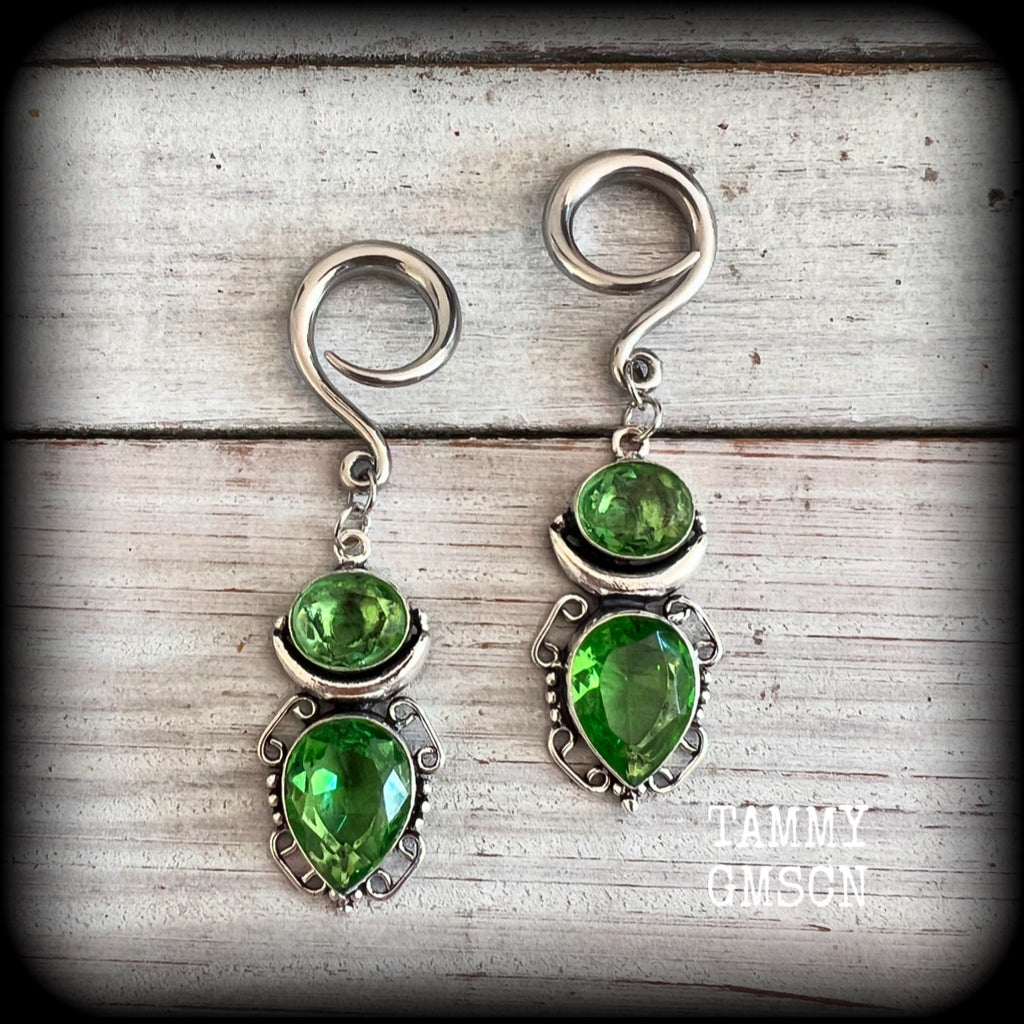 This pair of earrings features gorgeous green quartz and peridot gemstones in a boho antique silver setting, weighing approx 9 grams a piece and measuring approx 8cms from tip to tip.

This pair have been made on 6 gauge (4mm) surgical steel full curl hooks, to be worn in stretched lobes.
