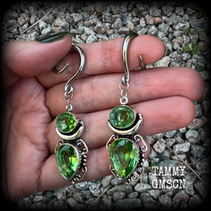 This pair of earrings features gorgeous green quartz and peridot gemstones in a boho antique silver setting, weighing approx 9 grams a piece and measuring approx 8cms from tip to tip.

This pair have been made on 6 gauge (4mm) surgical steel full curl hooks, to be worn in stretched lobes.
