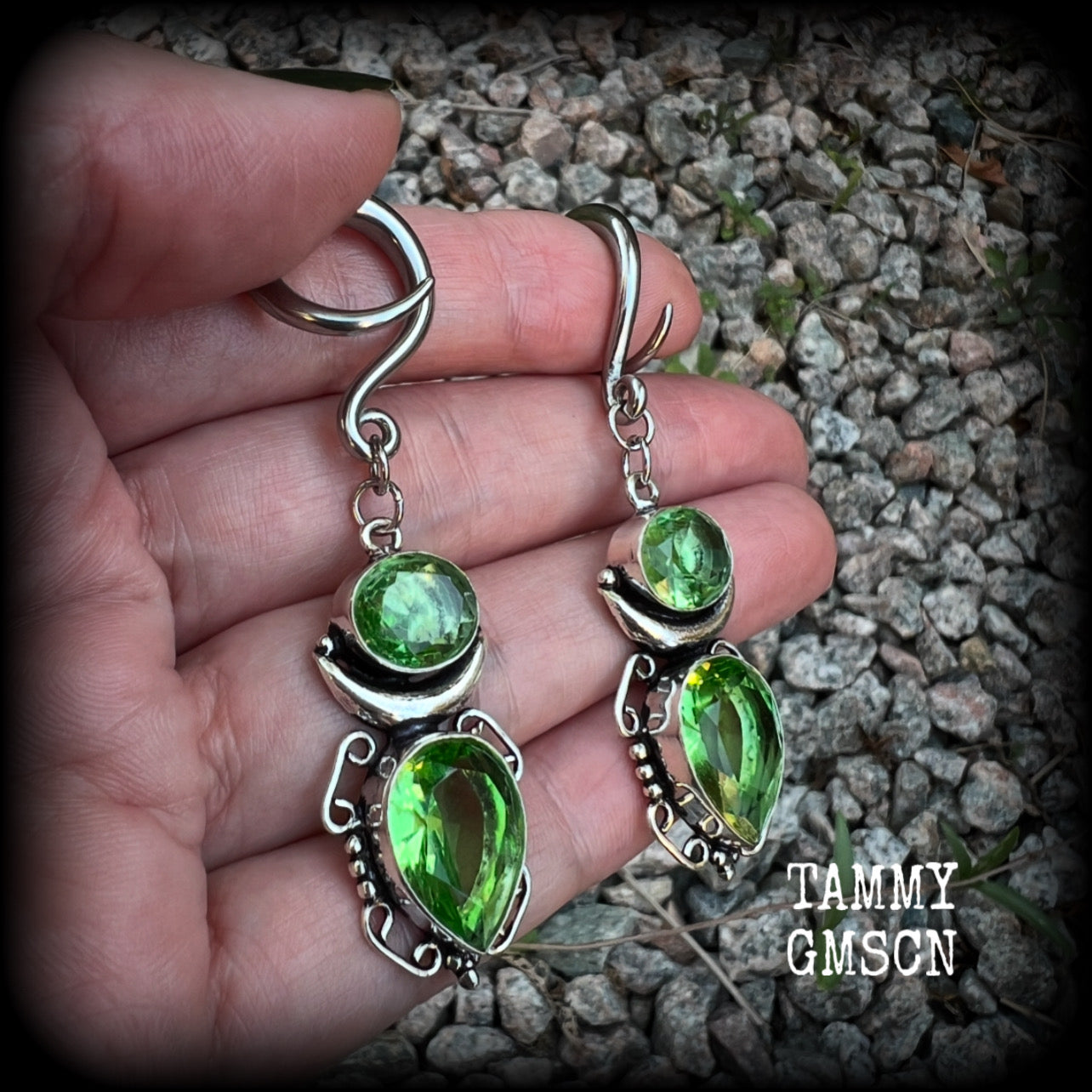 This pair of earrings features gorgeous green quartz and peridot gemstones in a boho antique silver setting, weighing approx 9 grams a piece and measuring approx 8cms from tip to tip.

This pair have been made on 6 gauge (4mm) surgical steel full curl hooks, to be worn in stretched lobes.
