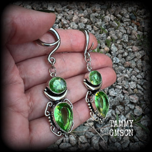 This pair of earrings features gorgeous green quartz and peridot gemstones in a boho antique silver setting, weighing approx 9 grams a piece and measuring approx 8cms from tip to tip.

This pair have been made on 6 gauge (4mm) surgical steel full curl hooks, to be worn in stretched lobes.
