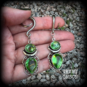 This pair of earrings features gorgeous green quartz and peridot gemstones in a boho antique silver setting, weighing approx 9 grams a piece and measuring approx 8cms from tip to tip.

This pair have been made on 6 gauge (4mm) surgical steel full curl hooks, to be worn in stretched lobes.
