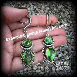 This pair of earrings features gorgeous green quartz and peridot gemstones in a boho antique silver setting, weighing approx 9 grams a piece and measuring approx 8cms from tip to tip.

This pair have been made on 6 gauge (4mm) surgical steel full curl hooks, to be worn in stretched lobes.
