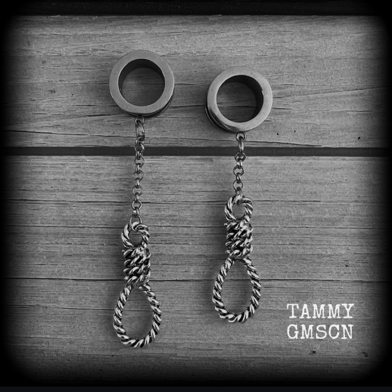 These awesome tunnel dangles feature classic antique silver hangmans nooses dangling from differing lengths of stainless steel chain, weighing only 11 grams each and measuring 9cms from tip to tip.

This pair has made on 5/8" (16mm) gauge standard surgical steel screw fit tunnels.
