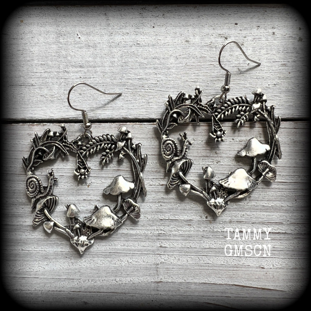 These awesome antique silver forest punk earrings are gorgeous!! 
Featuring a heart of ferns with snails, mushrooms and spiders, these earrings weigh approx 8 grams each, and measure in at just under 6cms from tip to tip.

This pair have been made on stainless steel french hooks, suitable for pierced ears.
