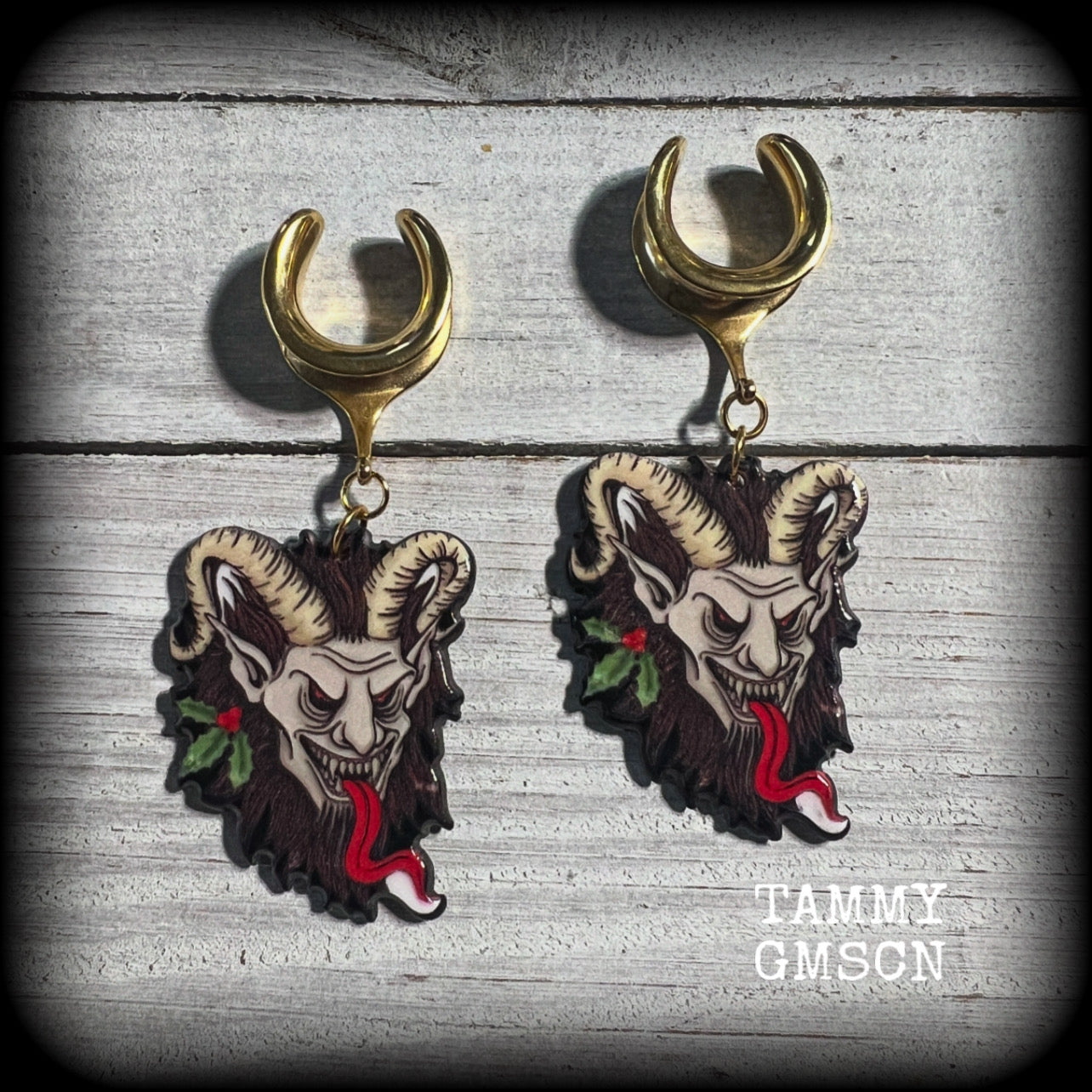 Featuring a festive horned Krampus nestled in sprigs of holly, these acrylic earrings are lightweight, weighing only 8 grams each and are nice and dangly, measuring just over 7 cms from tip to tip.

This pair has been made on surgical steel 5/8” (16mm) cradles, suitable for stretched lobes.