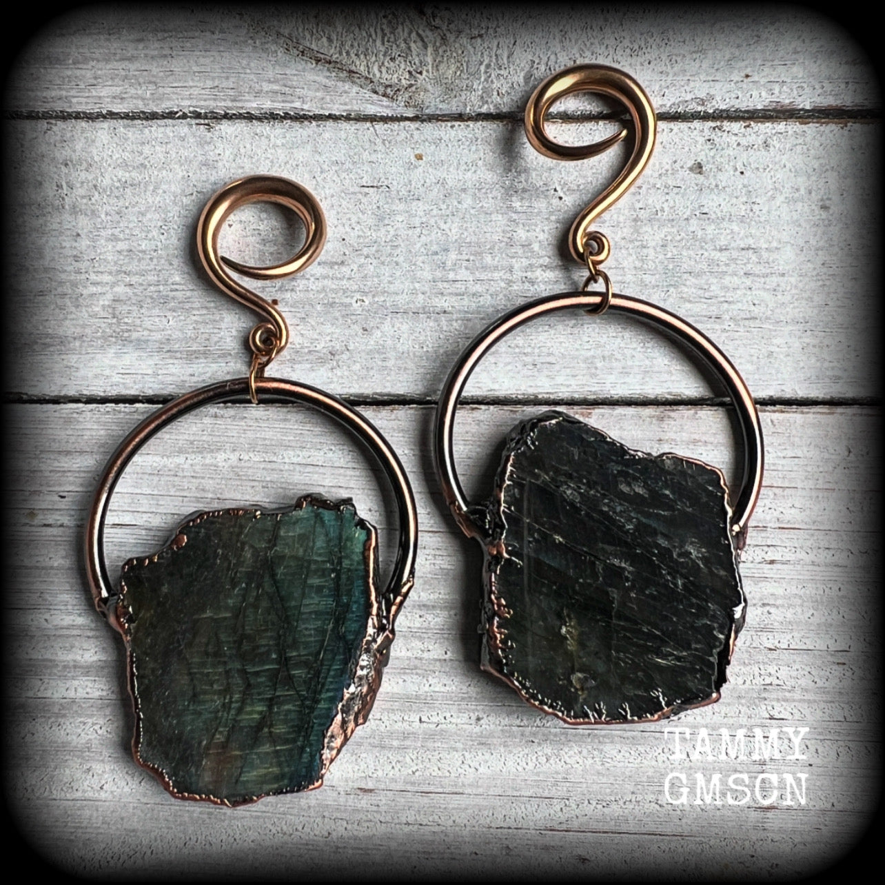 This pair of gorgeous earrings features large shimmering labradorite slices, weighing approx 25 grams a piece, not too heavy, and measuring just on 9cms from tip to tip.

These earrings have been made on 6 gauge (4mm) surgical steel full curl hooks, to be worn in stretched lobes.