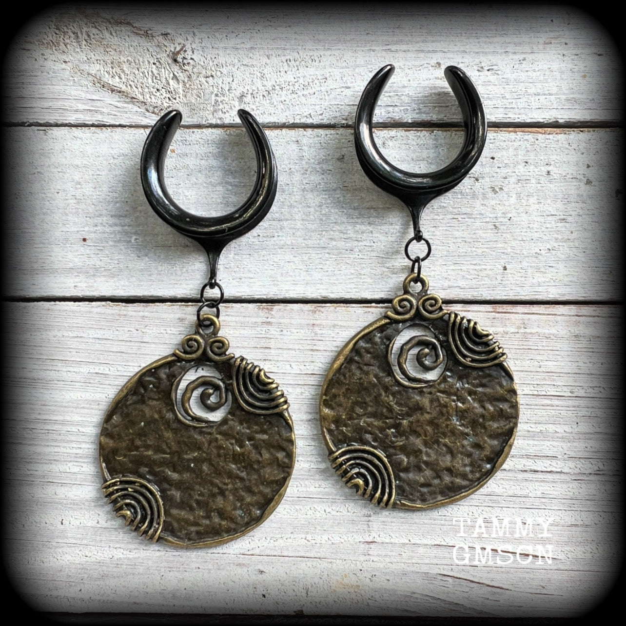 This pair of gauged earrings features big beautiful antique bronze tribal discs, lovely and dangly measuring just under 10cms from tip to tip and weighing in at 22 grams a piece.

This pair has been made on 3/4” gauge (19mm) surgical steel cradles, suitable for stretched lobes.