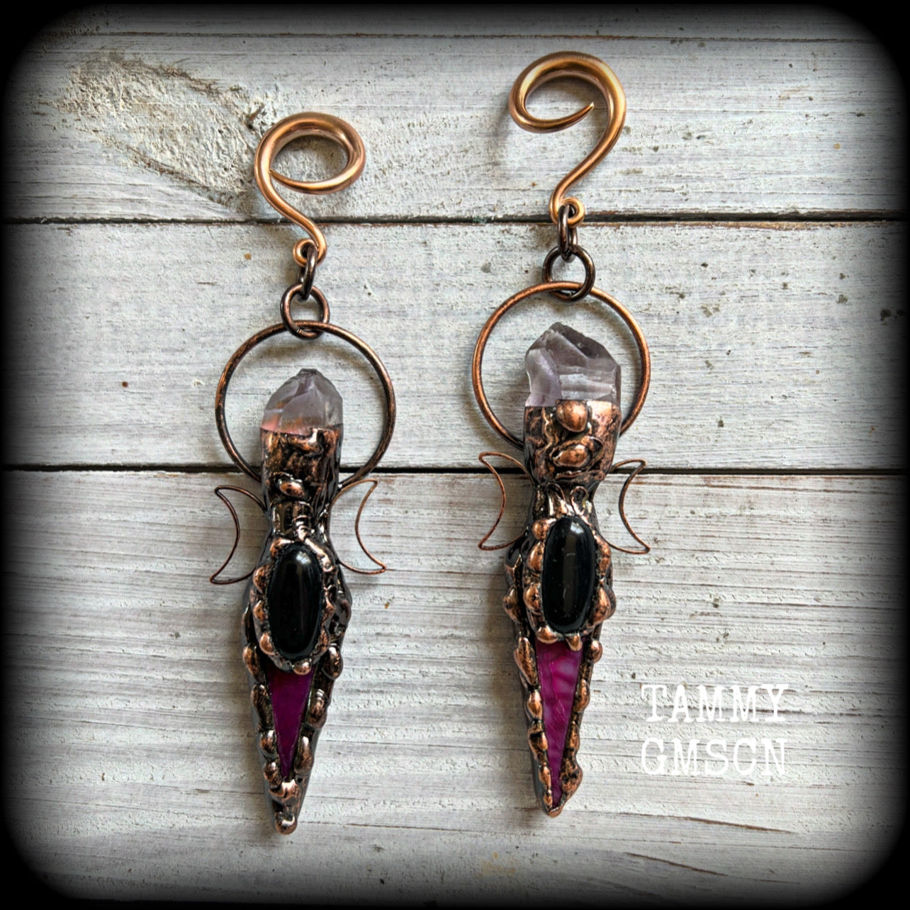 These pink quartz and black obsidian gauged earrings are stunning!!

Featuring gorgeous black obsidian gemstones with pink quartz gemstones in a rustic antique copper crescent moon setting, these gauged earrings measure just on 11.5 from tip to tip, and weigh approx 27 grams each.
 
This pair has been made on 6 gauge (4mm) rose tone surgical steel full curl hooks, suitable to be worn in stretched lobes.
