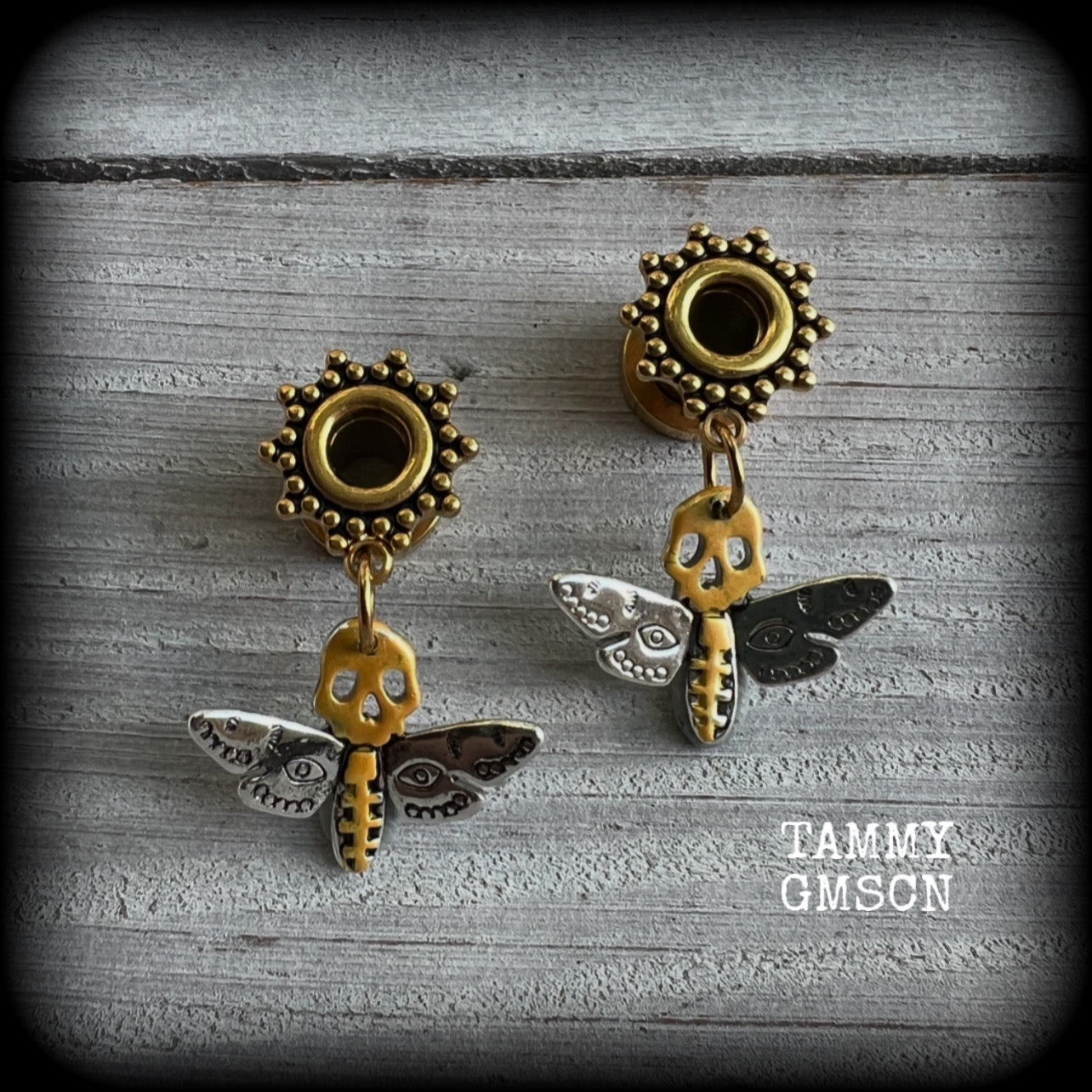 These unique tunnel earrings feature stunning antique silver and hand painted gold enamel deaths head moths, weighing only a few grams each, and measure approx 3cms from tip to tip.

This pair has been made on 2 gauge (6mm) ornate surgical steel screw fit tunnels.