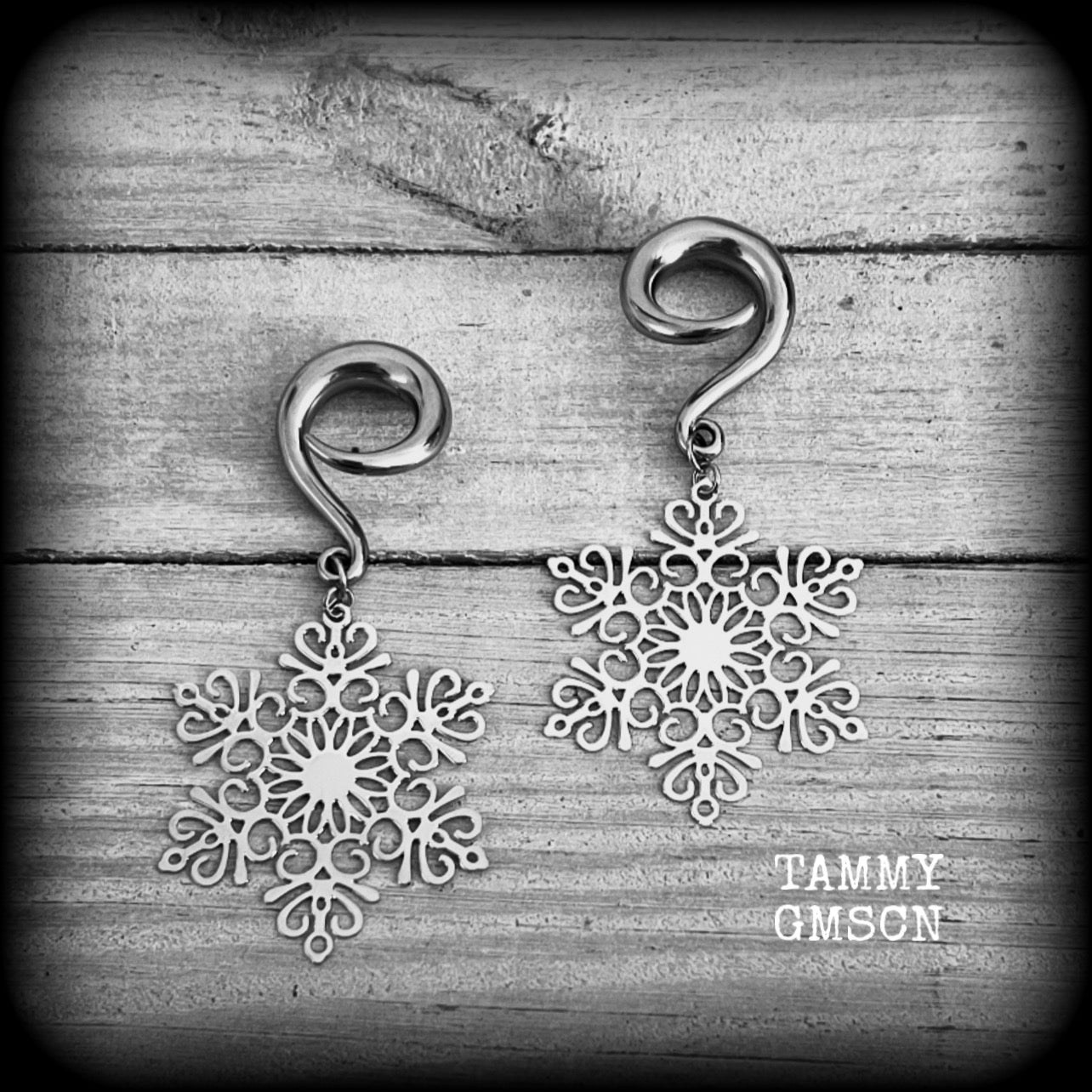 Featuring delicate stainless steel snowflake charms, these gorgeous earrings weigh approx 8 grams each, and are lovely and dangly at just over 7cms from tip to tip.

This pair has been made on 2 gauge (6mm) surgical steel full curl hooks, suitable for stretched lobes.
