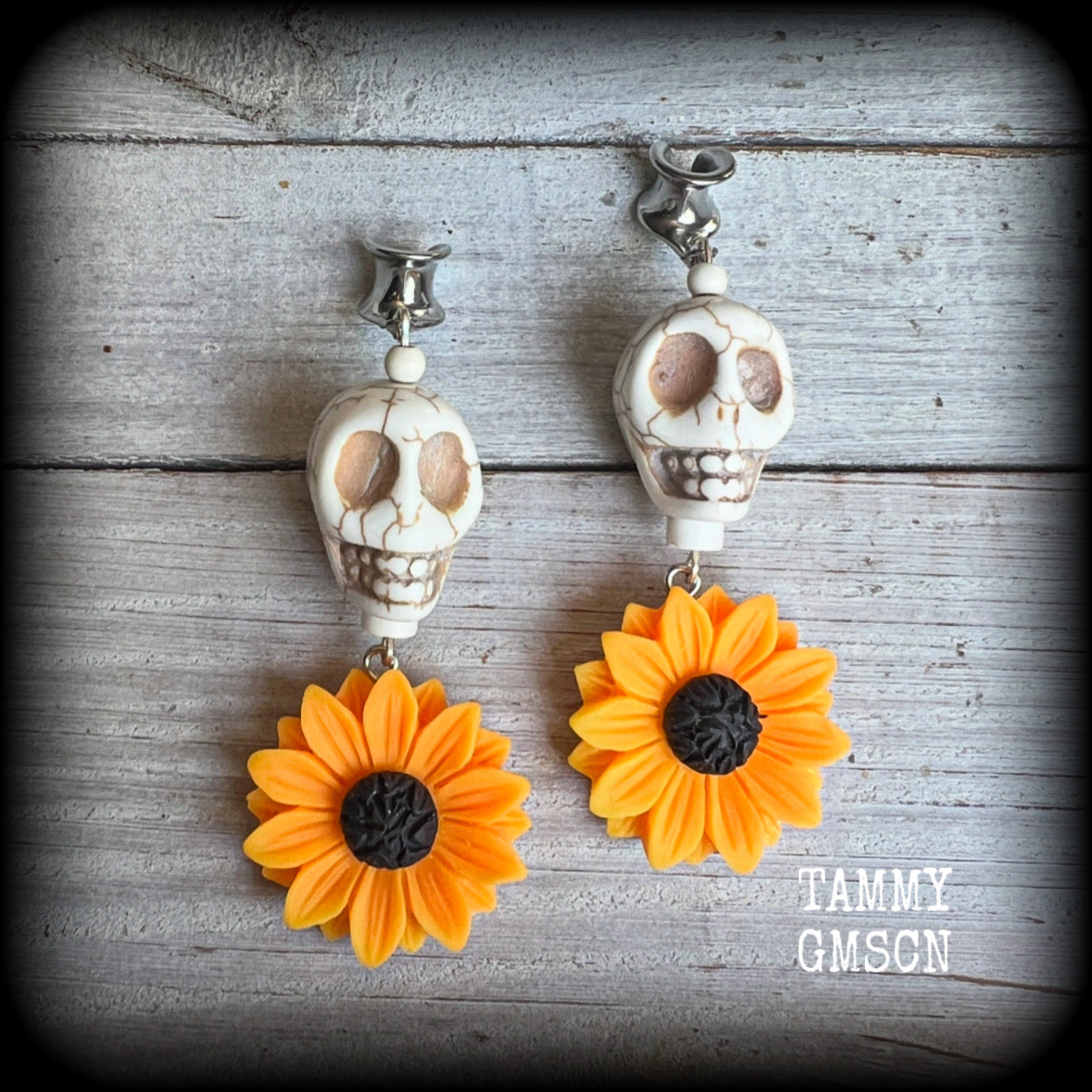 Featuring gorgeous orange sunflowers hanging beneath large bone white stone skulls, these earrings are big and beautiful !! 

These earrings weigh in at around 16 grams a piece, and nice and dangly at just under 8.5cms from tip to tip.

This pair have been made with 0 gauge (8mm) surgical steel cradles, suitable for stretched lobes.
