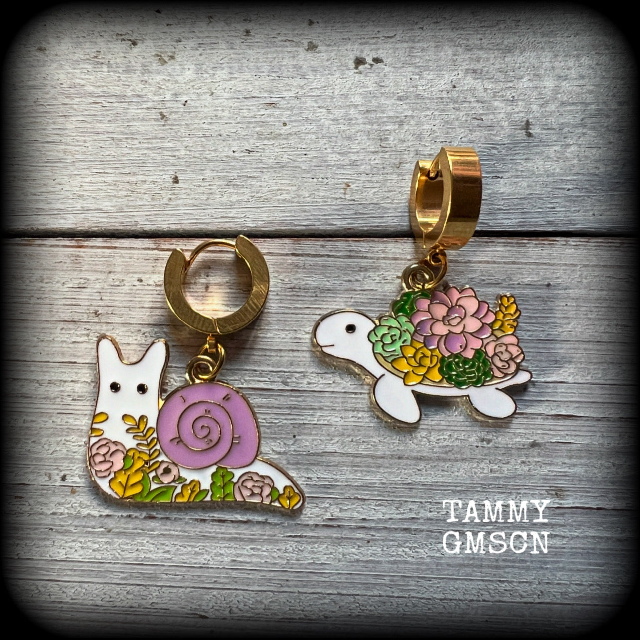 These adorable earrings feature antique gold and enamel garden snails and turtles with floral embellishments, are nice and lightweight at only a few grams each, and measure in at approx 4cm from tip to tip.

This pair have been made on stainless steel huggie ear cuffs, suitable for pierced ears.
