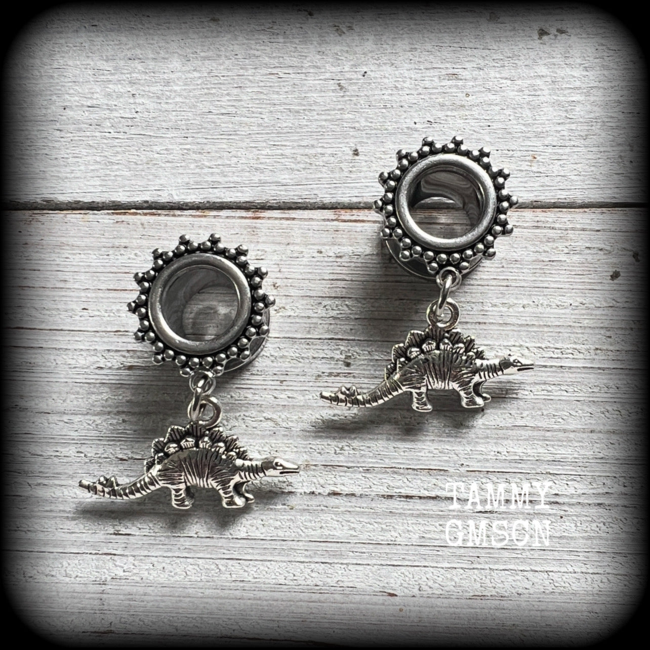 These quirky tunnel earrings feature adorable antique silver stegosaurus charms, measuring just under 4cms from tip to tip, and weighing approx 6 grams each.

This pair has been made on 00 gauge (10mm) surgical steel ornate screw fit tunnels.