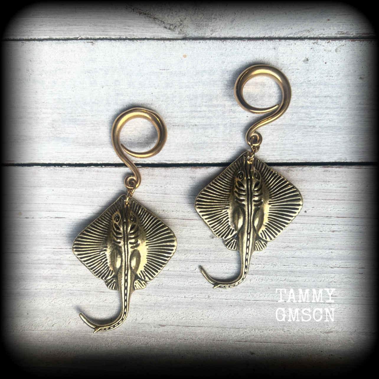 🔥 Symbolically, the stingray embodies calmness under pressure, self-defense, and navigating life's challenges with strength and balance.  

These awesome ear hangers feature a pair of brass sting rays, measuring just on 7cms from tip to tip, and weighing approx 17 grams each.

This pair has been made on 6 gauge (4mm) surgical steel full curls, suitable for stretched lobes.
