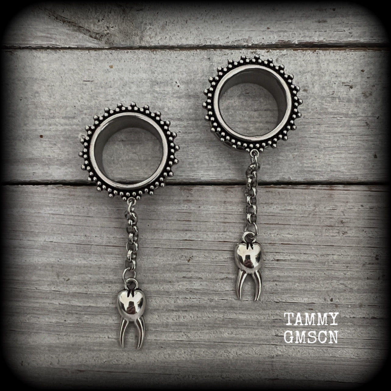 These gorgeous spooky tunnel dangles feature a classic antique silver molar tooth dangling from stainless steel chain, weighing approx 5 grams each and measuring 7cms from tip to tip.

This pair has made with 3/4" gauge (19mm) ornate surgical steel screw fit tunnels.