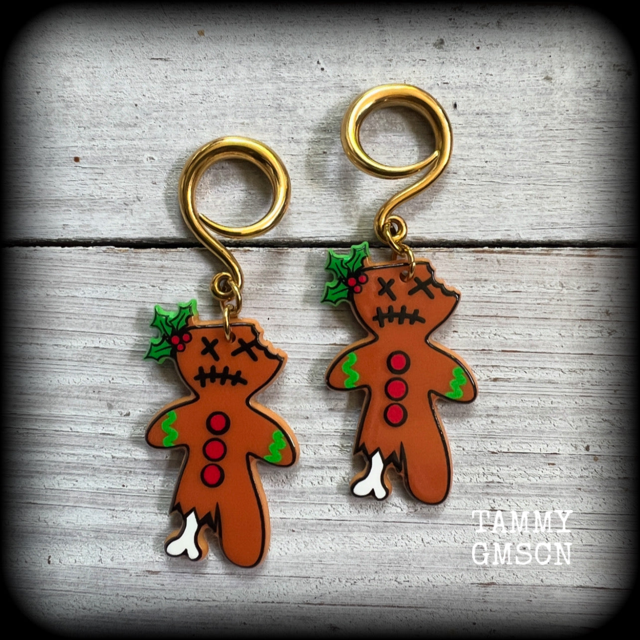 Featuring a festive half eaten zombie gingerbread man complete with sprig of holly, these acrylic earrings are lightweight, weighing approx 5 grams each and are nice and dangly, measuring just under 7 cms from tip to tip.

This pair has been made on surgical steel 6 gauge (4mm) full curls, suitable for stretched lobes.