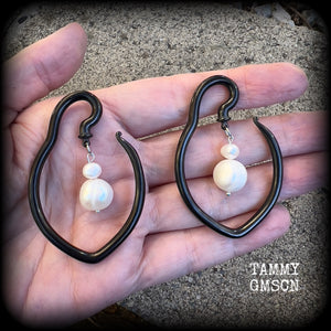 This is a pair of  titanium coated surgical steel hooks and repurposed ocean pearls, suitable to be worn through stretched lobes from 8 gauge (3mm).

Measuring approx 3.5cms across and almost 6cms from top to bottom, these weigh 13 grams a piece.