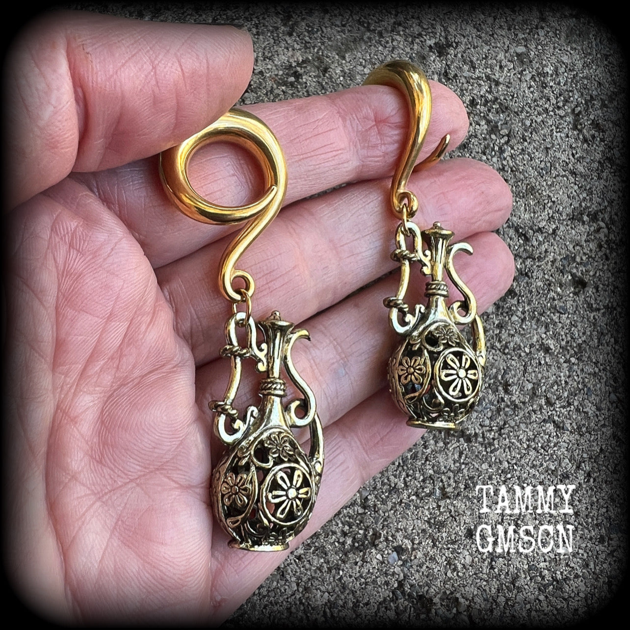 Inspired by the Star sign Aquarius-the water carrier, these gorgeous brass gauged earrings feature an ornate water jug, measuring 7 cms from tip to tip, and weighing approx 13 grams a piece.

This pair of earrings have been made on 2 gauge (6mm) surgical steel full curl hooks, suitable for stretched lobes.
