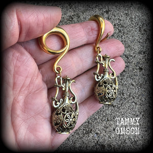 Inspired by the Star sign Aquarius-the water carrier, these gorgeous brass gauged earrings feature an ornate water jug, measuring 7 cms from tip to tip, and weighing approx 13 grams a piece.

This pair of earrings have been made on 2 gauge (6mm) surgical steel full curl hooks, suitable for stretched lobes.