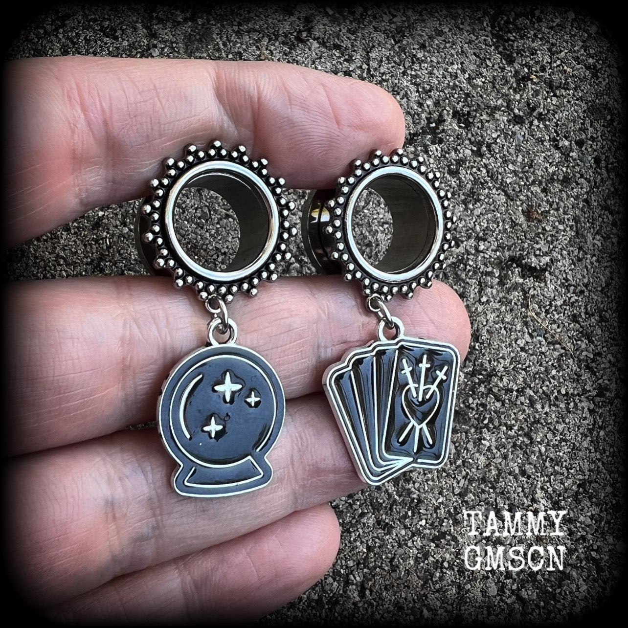 These gorgeous spooky tunnel dangles feature cute black enamel crystal ball and tarot card charms, are nice and lightweight-weighing only 7 grams each and measure 5cms from tip to tip.

This pair have been made on 5/8" (16mm) gauge ornate surgical steel screw fit tunnels.