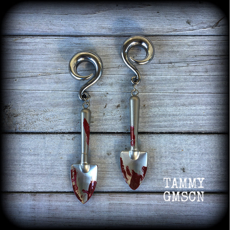 Our awesome ‘Grave digger’ gauged earrings feature a pair of b l o o d spattered stainless steel shovels weighing in at 24 grams a piece, and are nice and dangly at just over 10cms.

This pair has been made on 0 gauge (8mm) surgical steel full curl hooks, to be worn in stretched lobes.