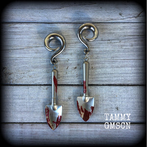 Our awesome ‘Grave digger’ gauged earrings feature a pair of b l o o d spattered stainless steel shovels weighing in at 24 grams a piece, and are nice and dangly at just over 10cms.

This pair has been made on 0 gauge (8mm) surgical steel full curl hooks, to be worn in stretched lobes.