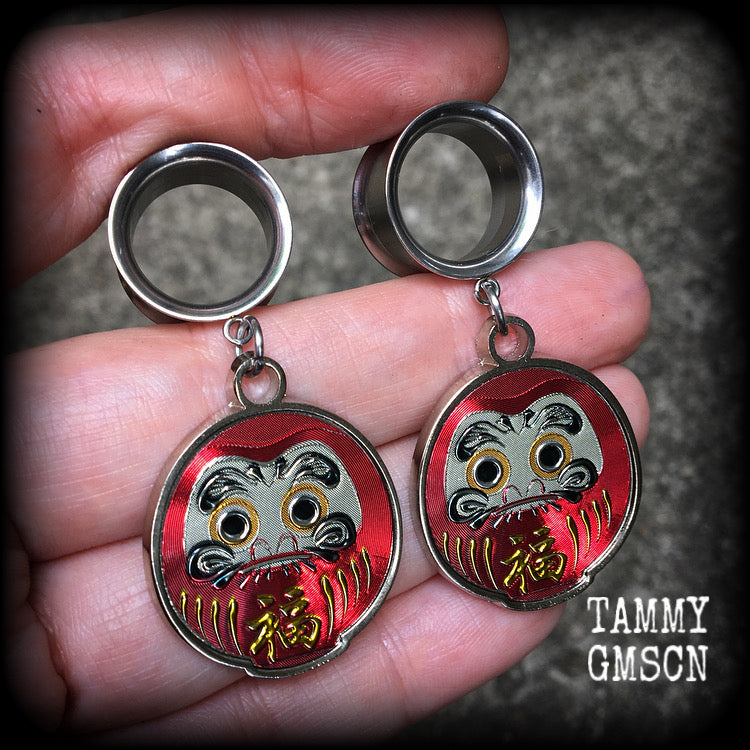 Red daruma dolls These gorgeous tunnel dangles feature stainless steel red daruma dolls, weighing approx 10 grams each and measuring approx 5.5cms from tip to tip.

This pair have been made with 9/16” gauge (14mm) surgical steel screw fit earlets.