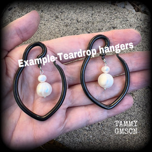 This is a pair of  titanium coated surgical steel hooks and repurposed ocean pearls, suitable to be worn through stretched lobes from 8 gauge (3mm).

Measuring approx 3.5cms across and almost 6cms from top to bottom, these weigh 13 grams a piece.