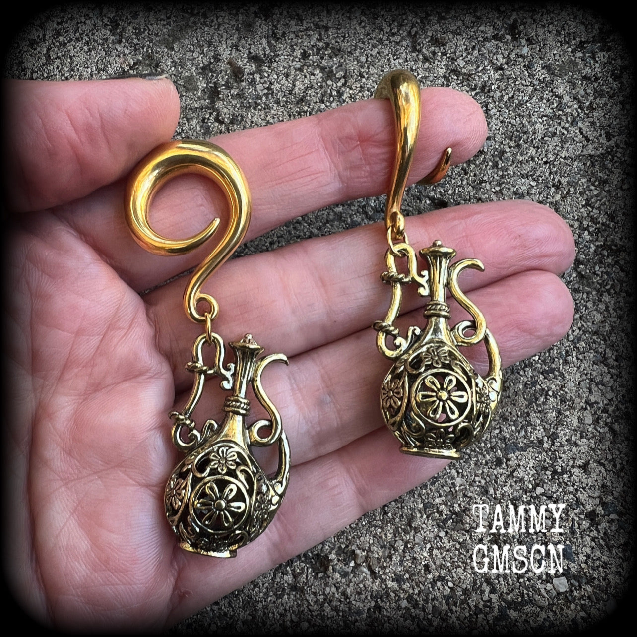 Inspired by the Star sign Aquarius-the water carrier, these gorgeous brass gauged earrings feature an ornate water jug, measuring 7 cms from tip to tip, and weighing approx 13 grams a piece.

This pair of earrings have been made on 2 gauge (6mm) surgical steel full curl hooks, suitable for stretched lobes.