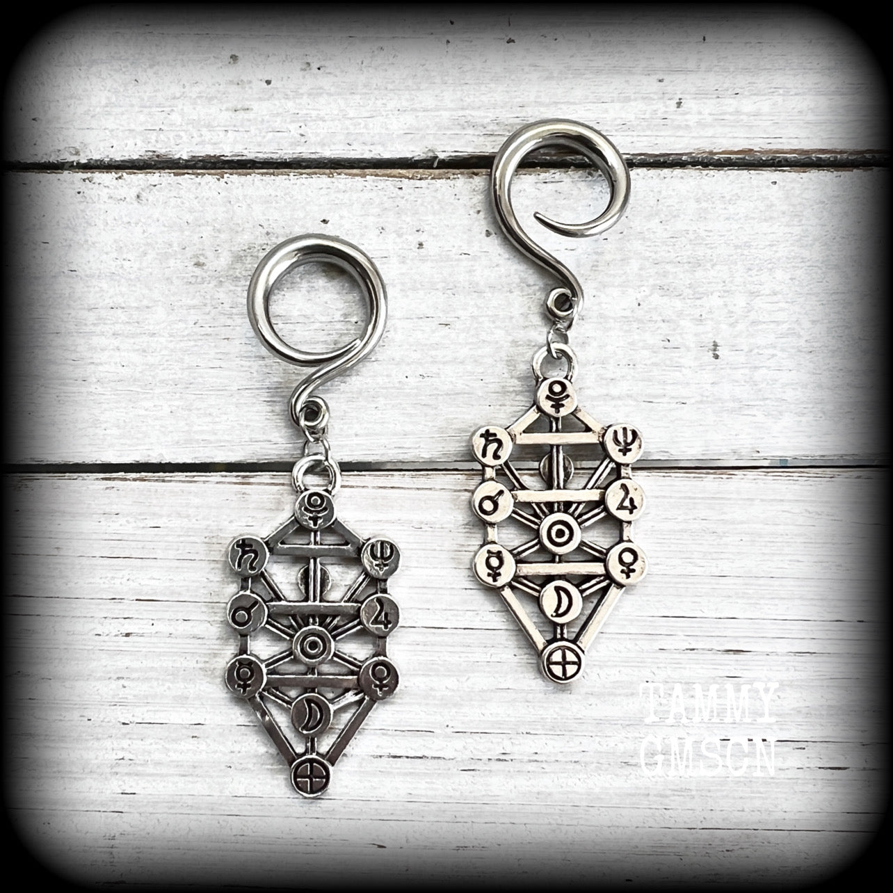 Our 'Tree of Life' gauged earrings feature stunning Kabalistic Tree of Life charms complete with sephiroth symbols. These earrings and are nice and dangly at just on 7cms, and weigh 8 grams a piece.
This pair has been made on 6 gauge (4mm) surgical steel full curl hooks, to be worn in stretched lobes.