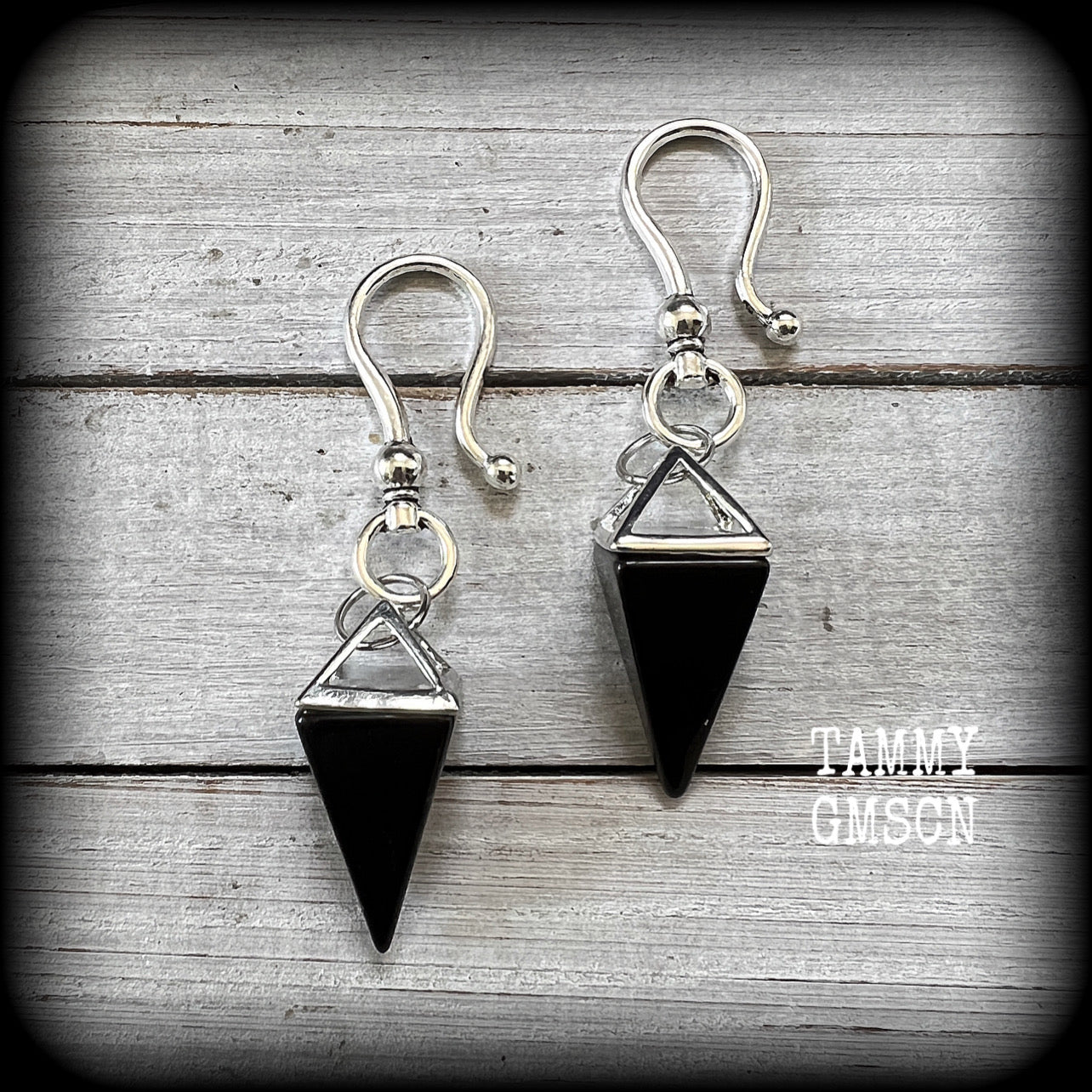 This is a pair of gorgeous pitch black onyx gemstone earrings, not too heavy at approx 10 grams a piece, and measuring just on 7cms from tip to tip.

This pair has been made with large antique silver shephards hooks, to be worn through silicone earlets in stretched lobes from 2 gauge (6mm).