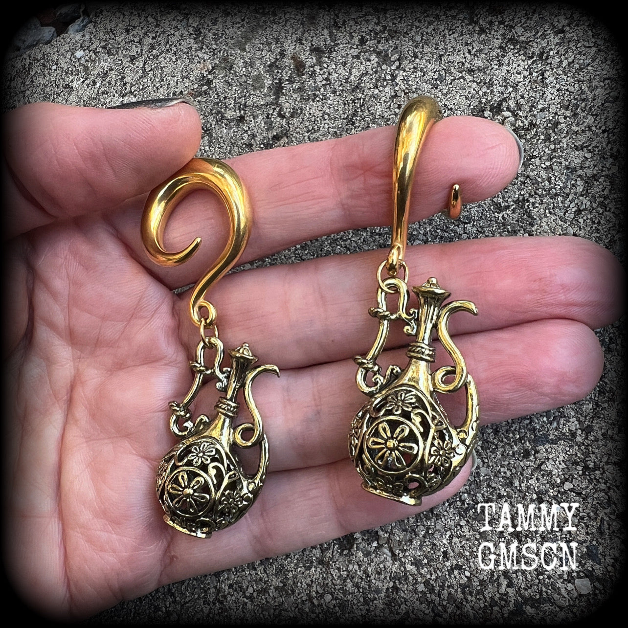 Inspired by the Star sign Aquarius-the water carrier, these gorgeous brass gauged earrings feature an ornate water jug, measuring 7 cms from tip to tip, and weighing approx 13 grams a piece.

This pair of earrings have been made on 2 gauge (6mm) surgical steel full curl hooks, suitable for stretched lobes.