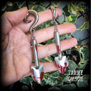 Our awesome ‘Grave digger’ gauged earrings feature a pair of b l o o d spattered stainless steel shovels weighing in at 24 grams a piece, and are nice and dangly at just over 10cms.

This pair has been made on 0 gauge (8mm) surgical steel full curl hooks, to be worn in stretched lobes.
