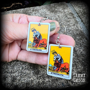 These classic Major Arcana earrings feature a lightweight plastic 'Strength' tarot card charm, measuring just under 6cms from tip to tip.

This pair has been made with stainless steel french hooks, suitable for pierced ears.