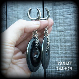 Steel saddles This is a pair of shiny black hematite donut gemstones with antique silver chain, weighing approx 50 grams a piece and measure just on 9cms from tip to tip.
This pair has been made on 5/8" gauge (16mm) surgical steel cradles,  for stretched lobes.