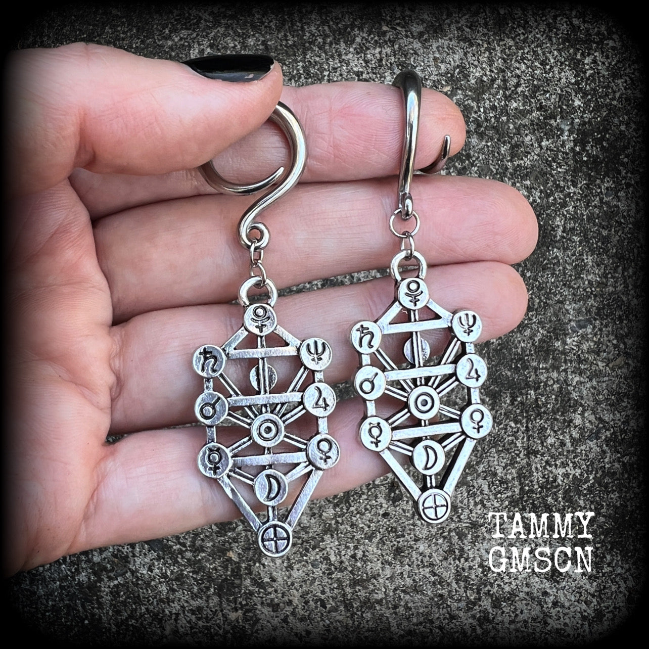 Our 'Tree of Life' gauged earrings feature stunning Kabalistic Tree of Life charms complete with sephiroth symbols. These earrings and are nice and dangly at just on 7cms, and weigh 8 grams a piece.
This pair has been made on 6 gauge (4mm) surgical steel full curl hooks, to be worn in stretched lobes.