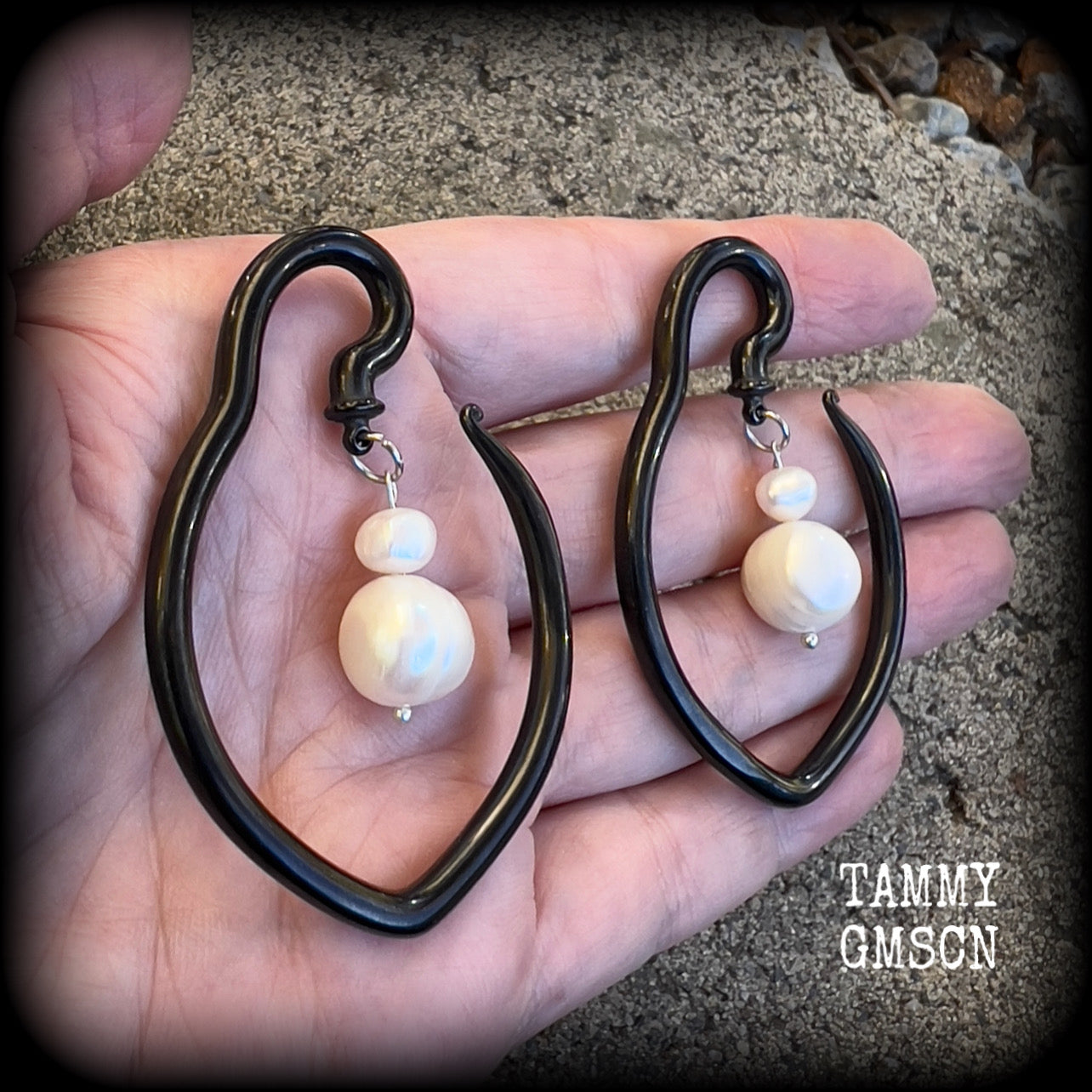 This is a pair of  titanium coated surgical steel hooks and repurposed ocean pearls, suitable to be worn through stretched lobes from 8 gauge (3mm).

Measuring approx 3.5cms across and almost 6cms from top to bottom, these weigh 13 grams a piece.