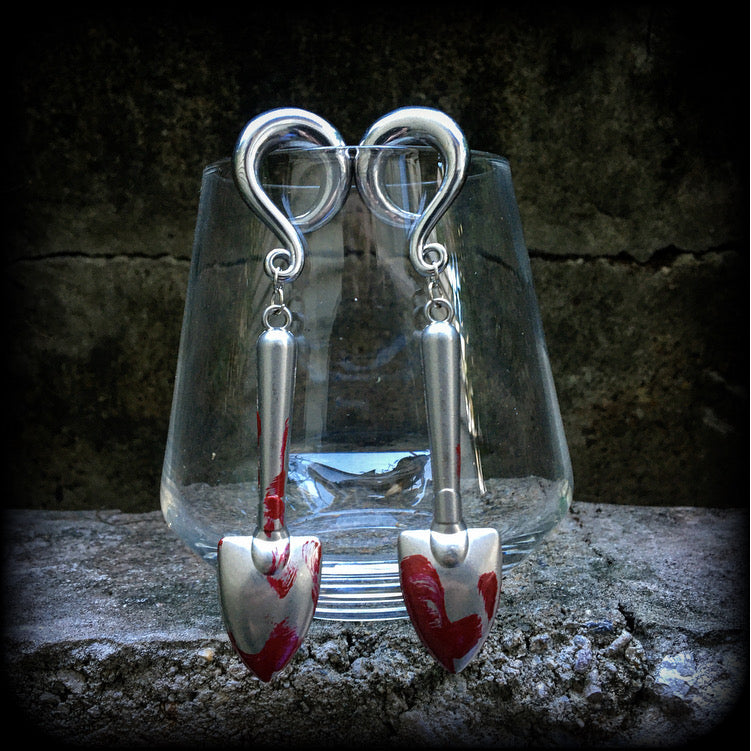 Our awesome ‘Grave digger’ gauged earrings feature a pair of b l o o d spattered stainless steel shovels weighing in at 24 grams a piece, and are nice and dangly at just over 10cms.

This pair has been made on 0 gauge (8mm) surgical steel full curl hooks, to be worn in stretched lobes.