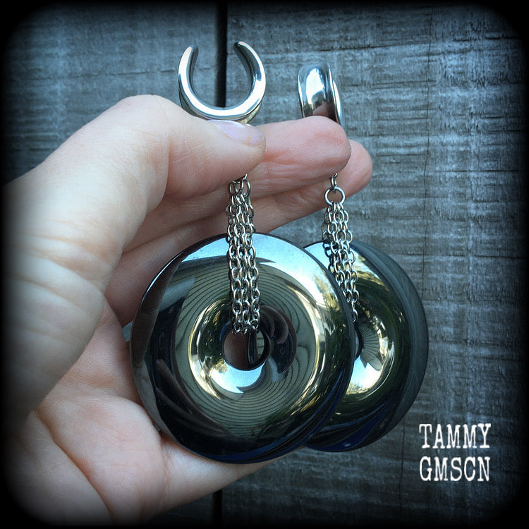 Gemstone gauged earrings This is a pair of shiny black hematite donut gemstones with antique silver chain, weighing approx 50 grams a piece and measure just on 9cms from tip to tip.
This pair has been made on 5/8" gauge (16mm) surgical steel cradles,  for stretched lobes.