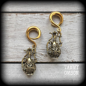 Inspired by the Star sign Aquarius-the water carrier, these gorgeous brass gauged earrings feature an ornate water jug, measuring 7 cms from tip to tip, and weighing approx 13 grams a piece.

This pair of earrings have been made on 2 gauge (6mm) surgical steel full curl hooks, suitable for stretched lobes.