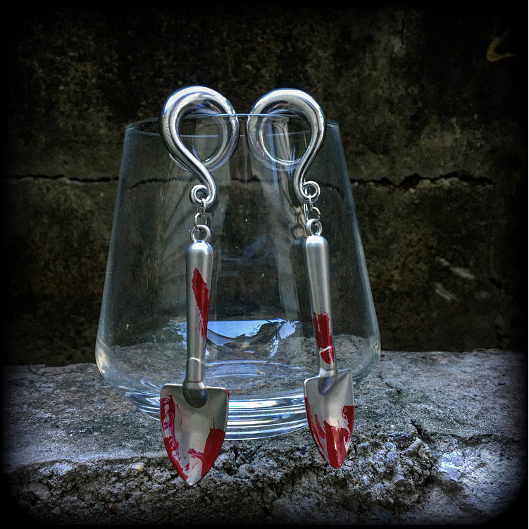 Our awesome ‘Grave digger’ gauged earrings feature a pair of b l o o d spattered stainless steel shovels weighing in at 24 grams a piece, and are nice and dangly at just over 10cms.

This pair has been made on 0 gauge (8mm) surgical steel full curl hooks, to be worn in stretched lobes.