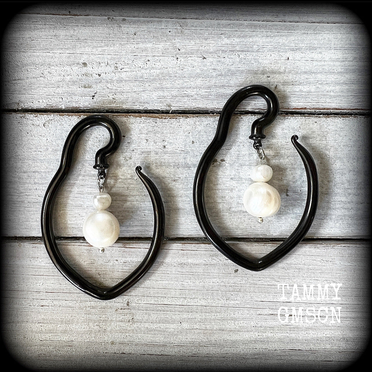 This is a pair of  titanium coated surgical steel hooks and repurposed ocean pearls, suitable to be worn through stretched lobes from 8 gauge (3mm).

Measuring approx 3.5cms across and almost 6cms from top to bottom, these weigh 13 grams a piece.