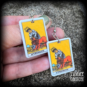 These classic Major Arcana earrings feature a lightweight plastic 'Strength' tarot card charm, measuring just under 6cms from tip to tip.

This pair has been made with stainless steel french hooks, suitable for pierced ears.