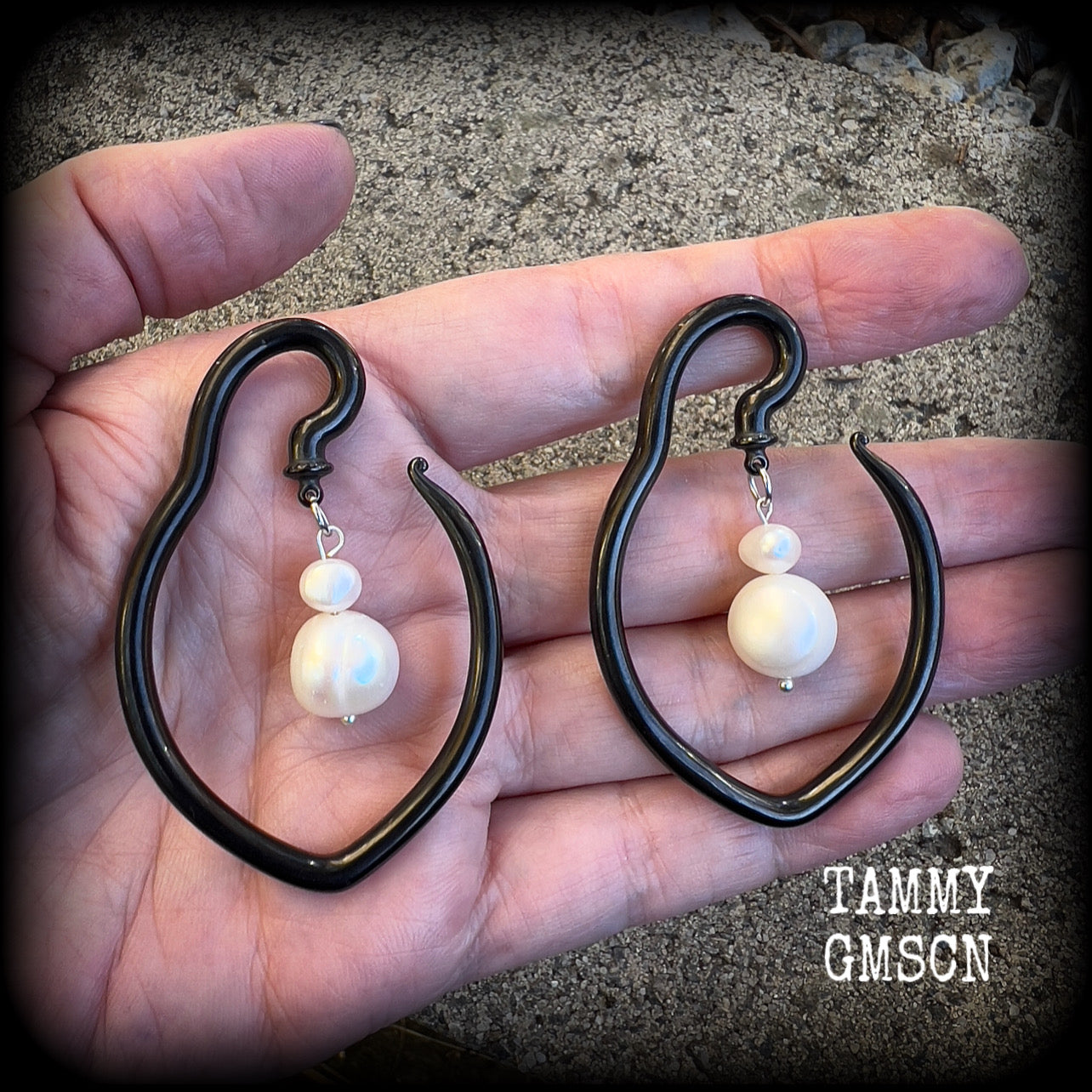 This is a pair of  titanium coated surgical steel hooks and repurposed ocean pearls, suitable to be worn through stretched lobes from 8 gauge (3mm).

Measuring approx 3.5cms across and almost 6cms from top to bottom, these weigh 13 grams a piece.