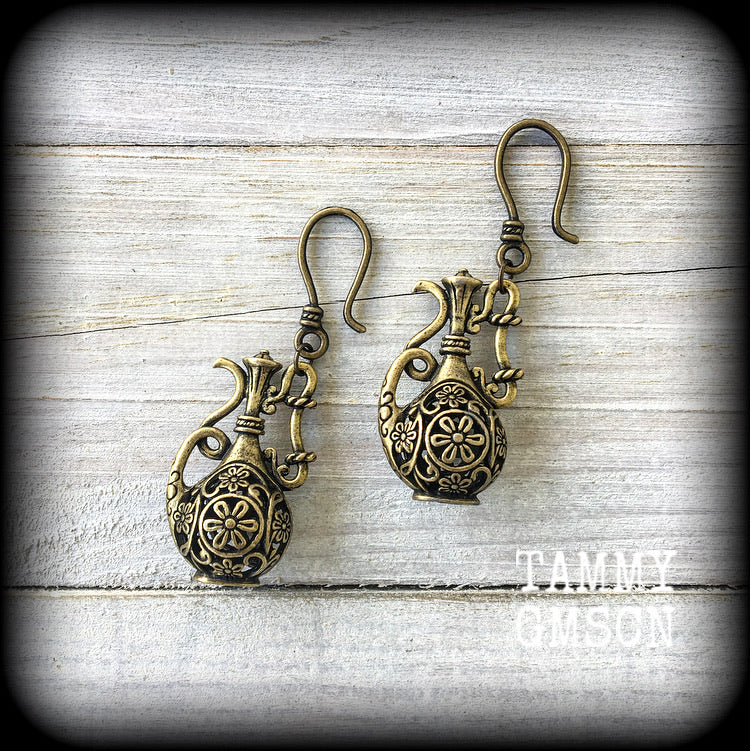 Inspired by the Star sign Aquarius-the water carrier, these gorgeous antique bronze earrings feature an ornate water jug, measure just on 7cms, and weigh 9 grams a piece, not too heavy...

This pair have been made with small antique bronze shephards hooks to be worn through silicone earlets in stretched lobes from 8 gauge (3mm).