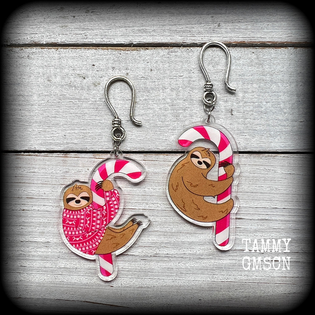 These adorable Christmas earrings feature festive acrylic sloths clinging to pink and white striped candy canes! These earrings are super cute and super lightweight, weighing only a few grams each and measuring just over 7 cms from tip to tip.

This pair have been made with small antique silver shephard hooks, suitable for stretched lobes when worn with silicone earlets from 8 gauge (3mm).