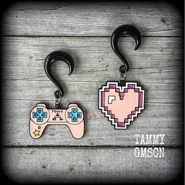 These awesome gamer girl gauged earrings feature a pink pixel heart with matching pink hand control, measuring just over 6cms from tip to tip and weighing 10 grams a piece.

This pair has been made on 2 gauge (6mm) surgical steel half curl hooks, suitable for stretched lobes.