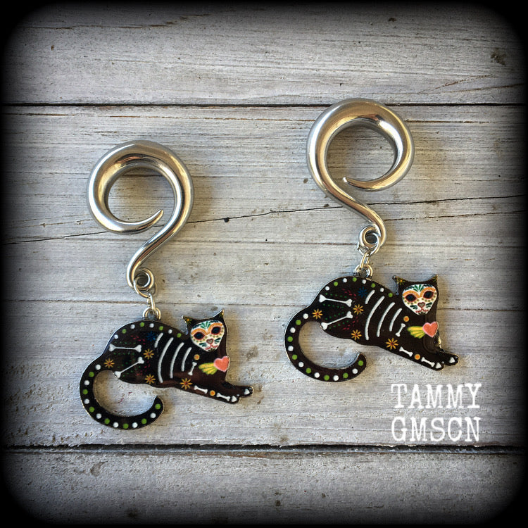 These gorgeous gauged earrings feature a Day of the Dead sugar skull style black cat, cute and spooky!!
These are nice and dangly, measuring just under 6 cms from tip to tip and weigh approx 11 grams each.

This pair has been made on 2 gauge (6mm) surgical steel full curl hooks, to be worn in stretched lobes.